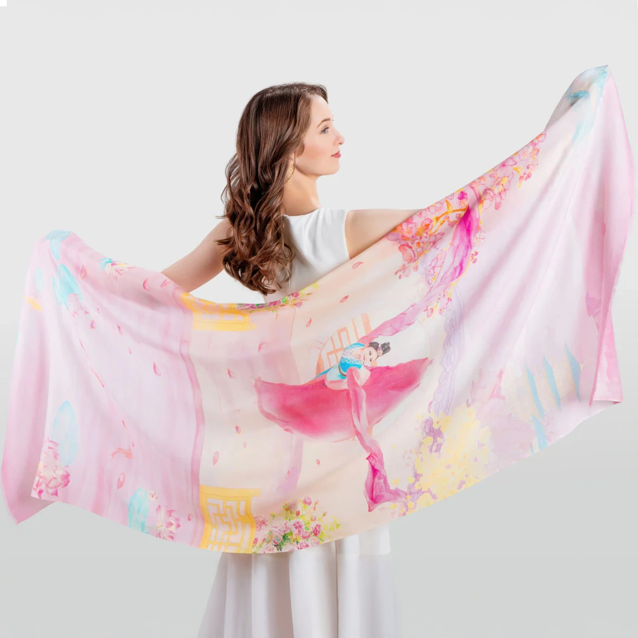 A woman stretches out a colourful scarf behind her back