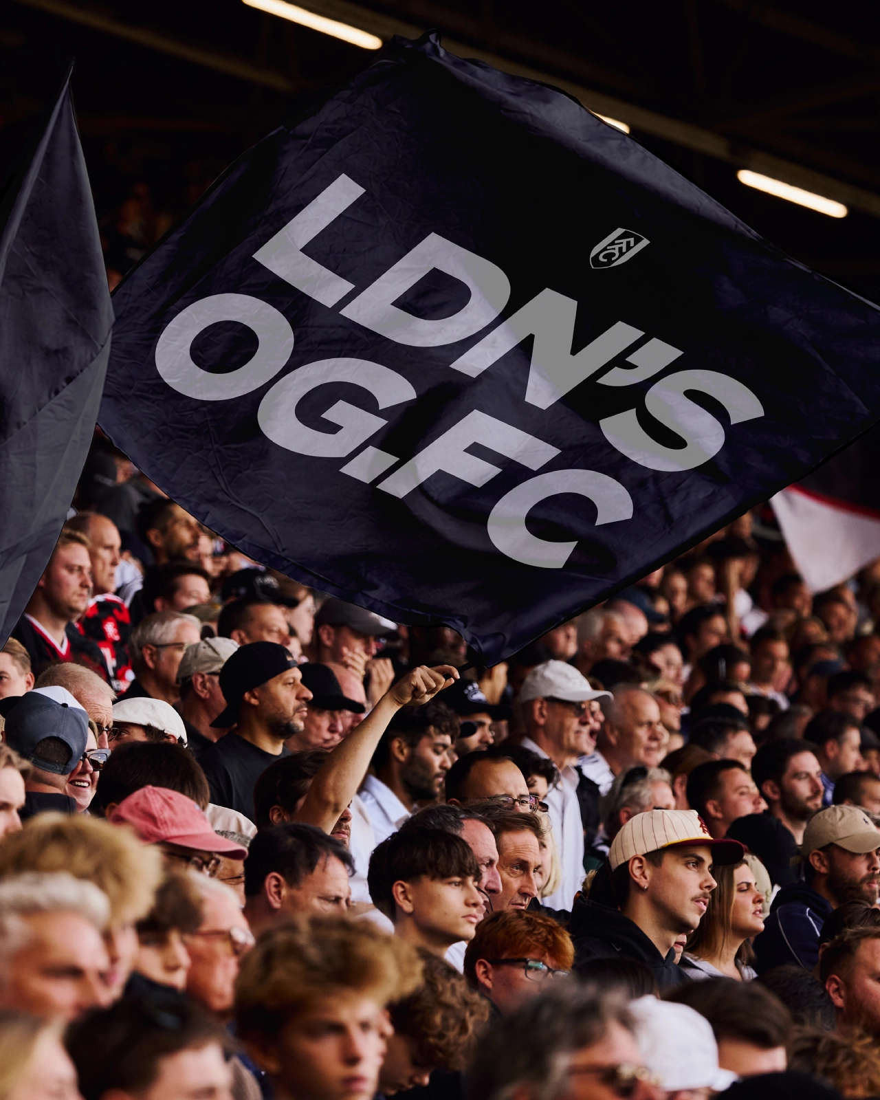 Navy Fulham FC flag held aloft by supporters in the stadium crowd