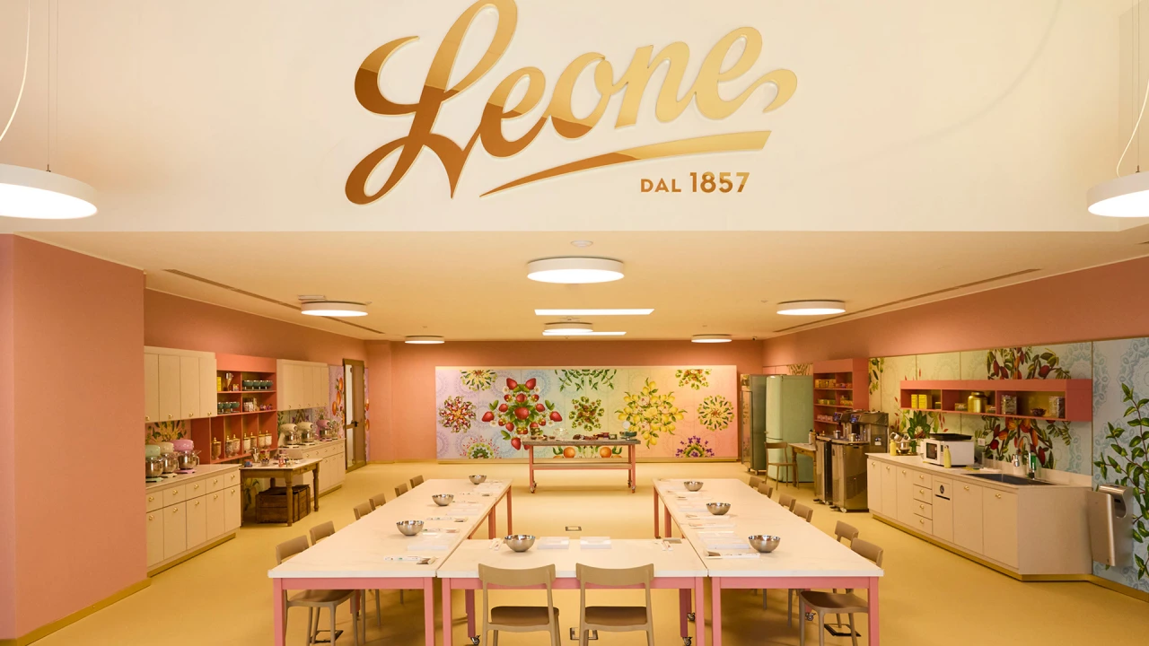 Leone's retro-style Happiness Factory interior with golden logo, orange walls, vintage kitchen setup and central dining table surrounded by chairs