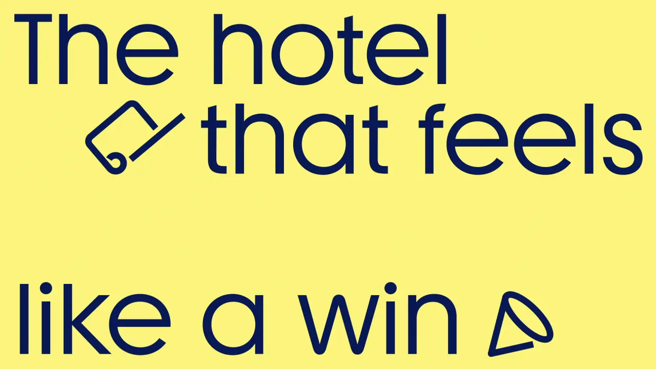 Bright yellow banner with navy text reading "The hotel that feels like a win" with a simple line-drawn paper aeroplane icon