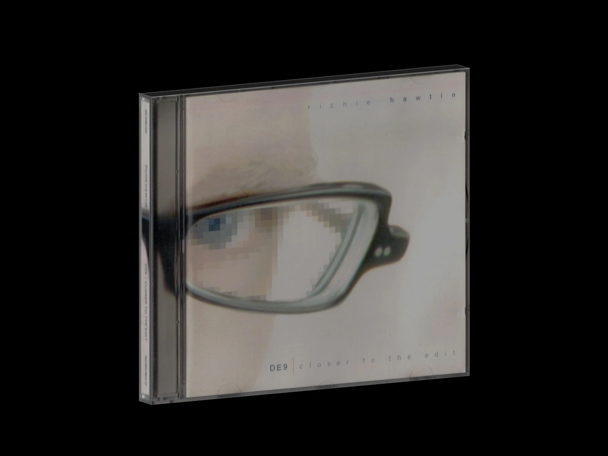 CD case for Richie Hawtin's landmark techno album DE9, featuring a close-up of spectacles on a pale background