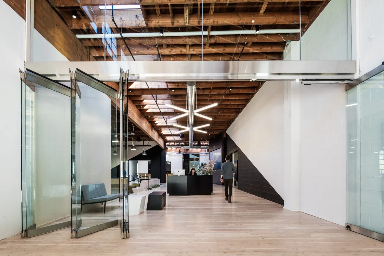 Swift Main Entrance: A glass accordion door folds flat to join the reception area  and covered courtyard entryway.