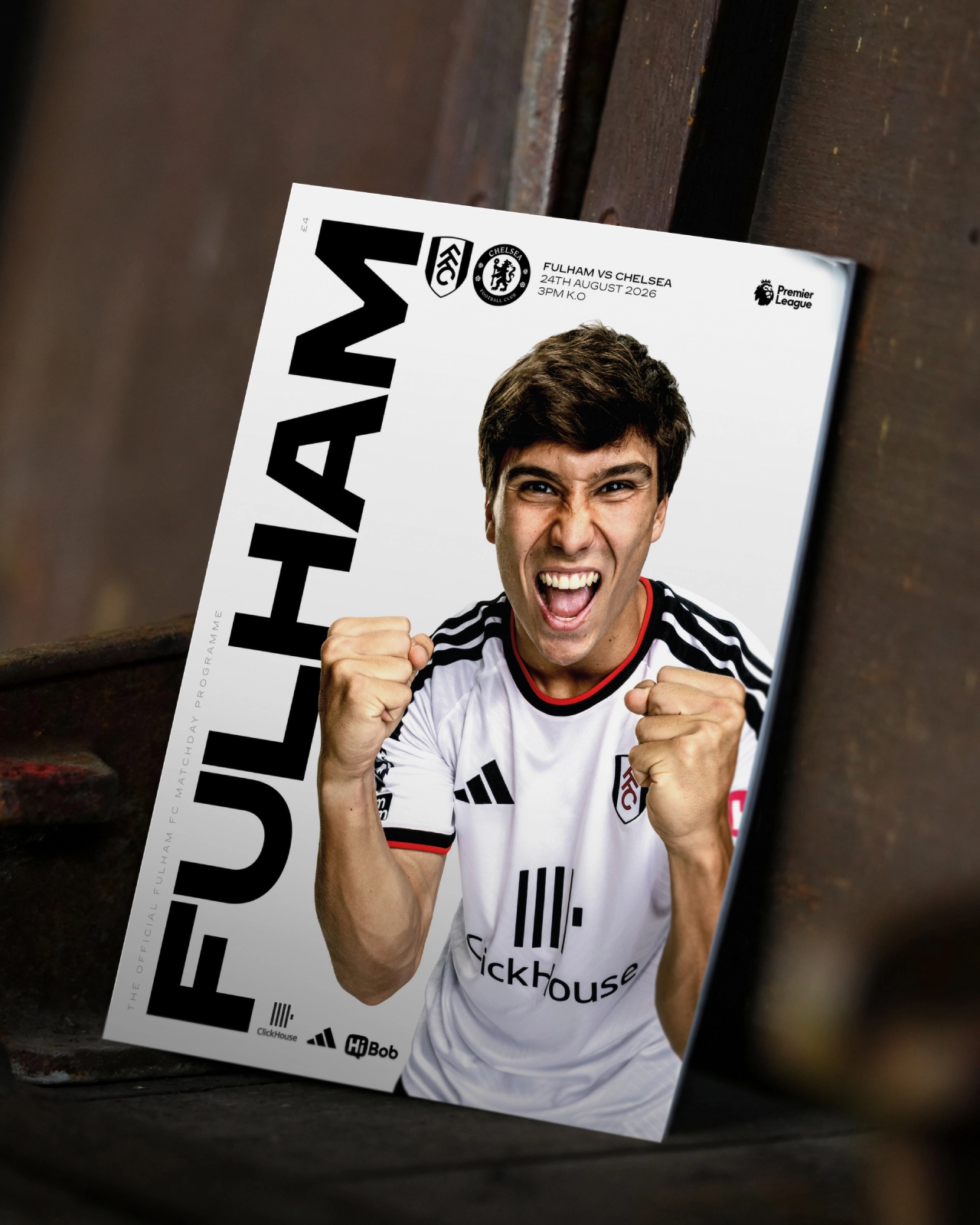 Fulham FC match programme cover featuring a player in white kit with clenched fists, alongside large "FULHAM" text and Premier League branding