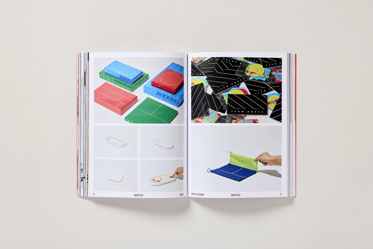 Open book spread showing colourful translucent storage boxes, packaging designs and hands holding blue and green fabric items demonstrating product merchandise applications
