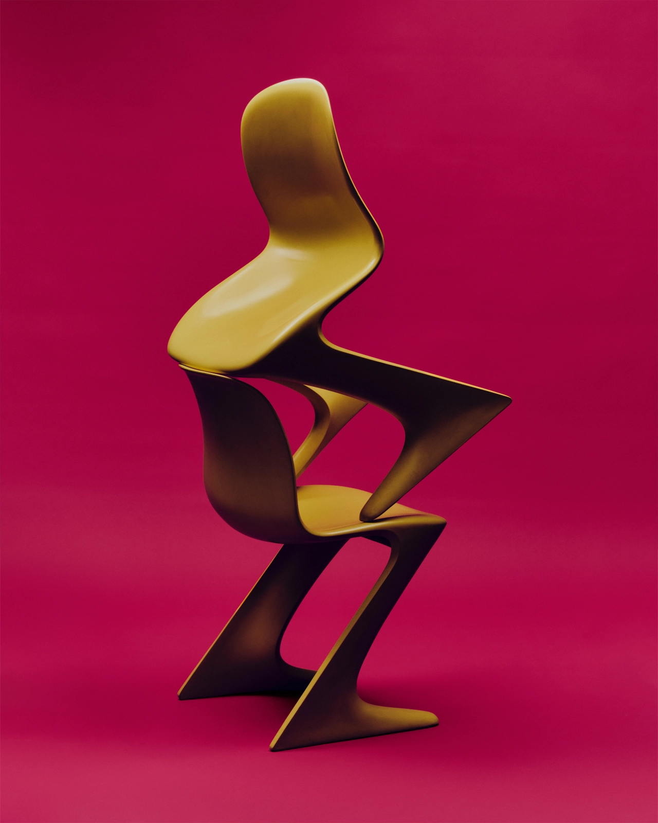 Stacked abstract chairs in mustard yellow and black against a vibrant magenta background, casting dramatic shadows