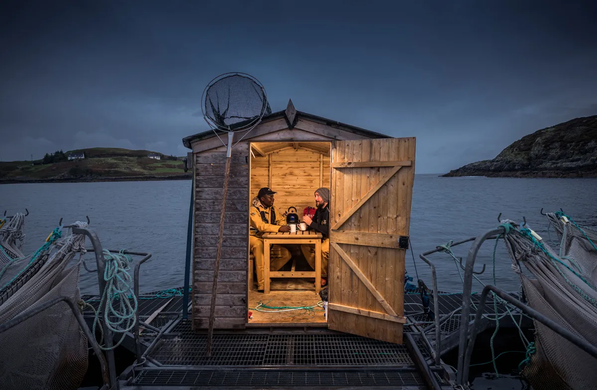 "Daniel (left) travelled from Nigeria to the northwest of Scotland to fulfil his dream of working as a marine biologist. It is one of the wildest and wettest parts of the UK but he has fallen in love with the area and plans to stay." – Night Watch at Salmon Farm © Euan Myles