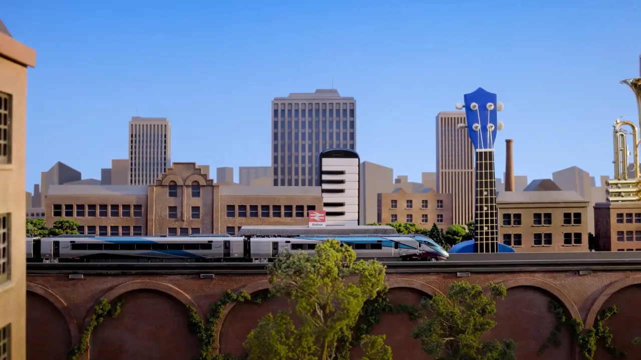The train soars past over-sized objects such as an ukulele...