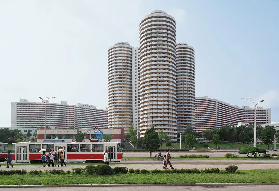 Cylindrical apartment towers for the Pyongyang elite line down the 4km- long avenue of Kwangbok Street, a ceremonial boulevard built for the 1989 World Festival of Youth and Students. As Kim Jong Il wrote approvingly: "In the formation of Kwangbok Street, a large variety of shapes, such as cylinders, windmills, polygons, the letter S and steps, were adopted for apartment blocks. [...] The arrangement of buildings on straight lines along the main street is an outmoded method." Copyright: © Oliver Wainwright