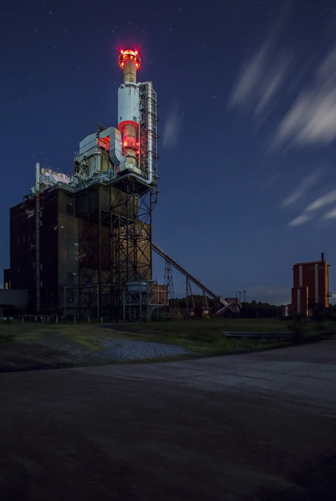 ) Sitting on the edge of town this disused giant structure casts its bright red lights into the night sky. A cry for attention for a neglected building?