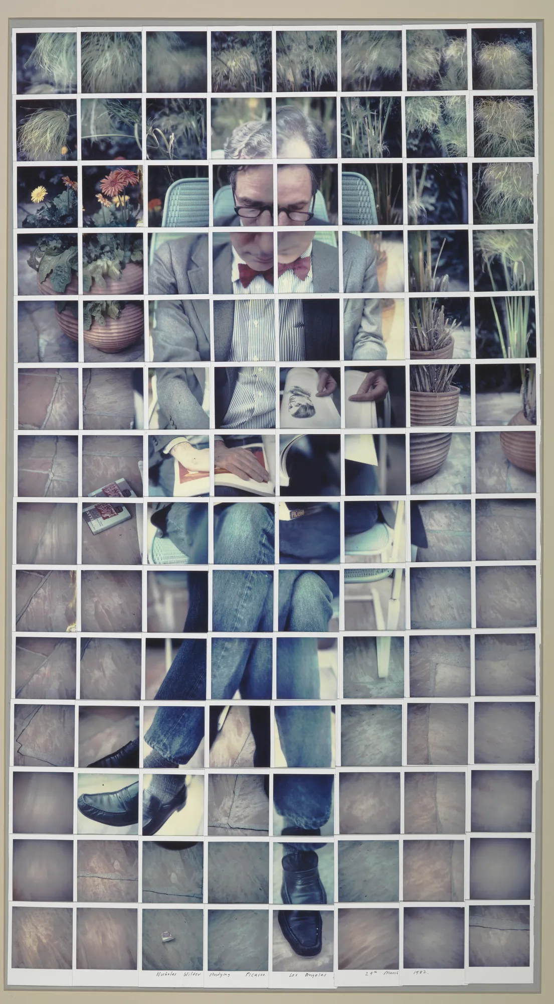 David Hockney "Nicholas Wilder Studying Picasso. Los Angeles 24th March 1982." Composite polaroid 48 1/2 x 26 1/2" © David Hockney Photo Credit: Richard Schmidt