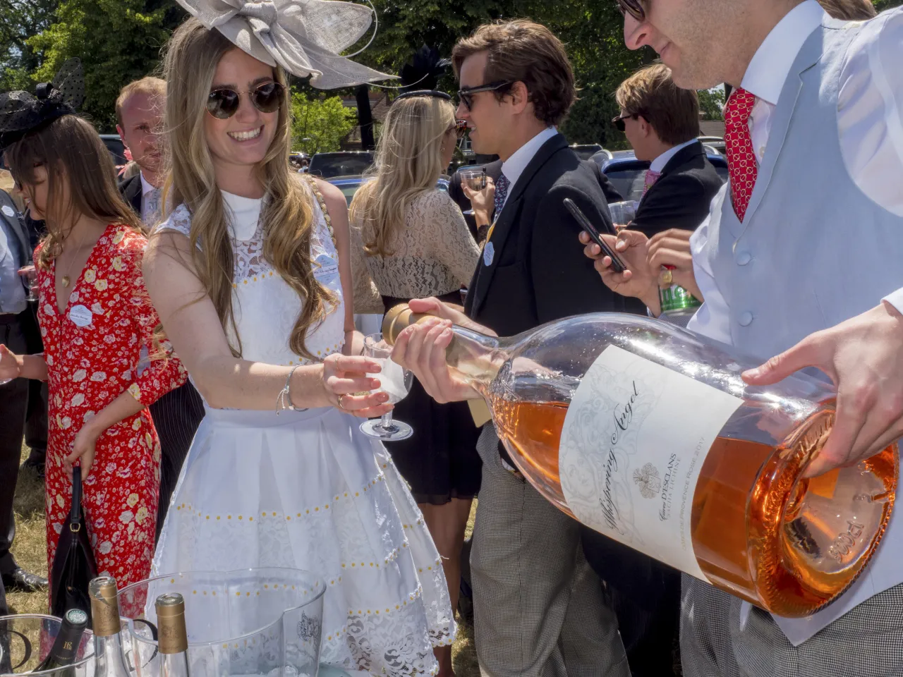 A giant bottle of rosé wine is poured for a guest at a picnic at the Royal Enclosure's Car Park One on Ladies Day at Royal Ascot. June 2018 © Peter Dench