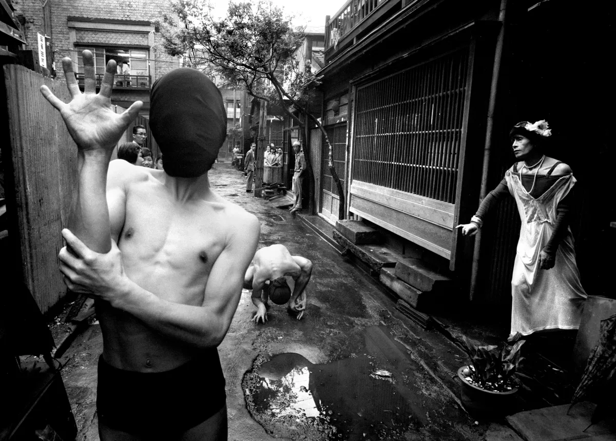 Dancers interpret Genet’s Notre-Dame-des-Fleurs in street of small offices, Tokyo, 1961 © William Klein