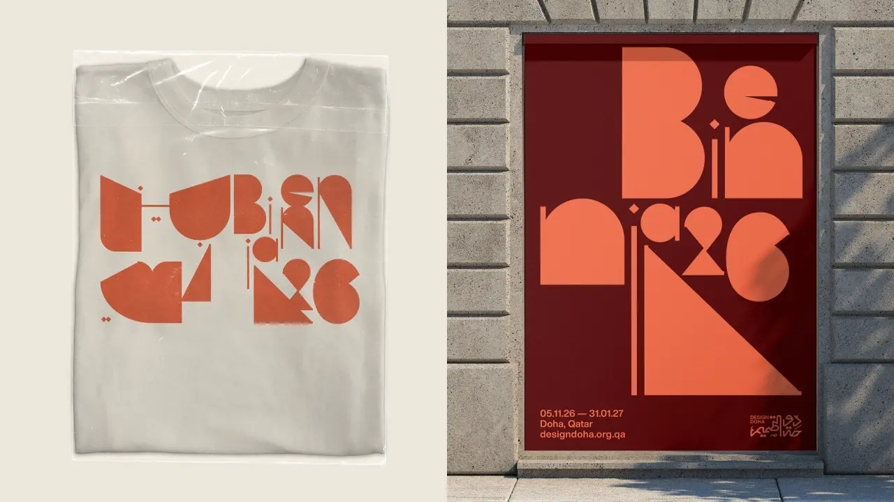 White t-shirt and maroon poster both displaying the Design Doha Biennial 2026 identity, with interlocking orange geometric letterforms representing Arabic and English text