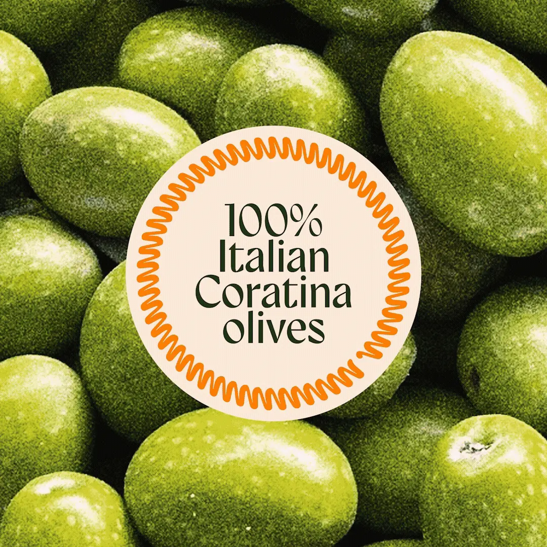A circular label with an orange wavy border on bright green Coratina olives reads "100% Italian Coratina olives