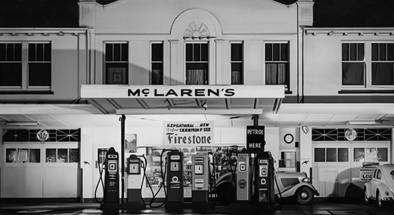 Black and white photograph of McLaren's service station in Auckland, showing vintage petrol pumps and signage with the original McLaren wordmark above the storefront