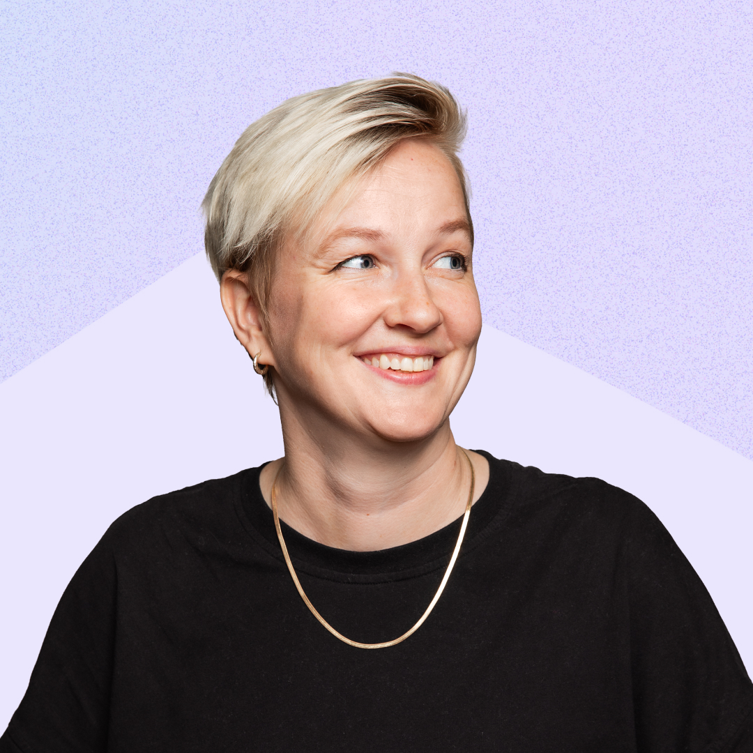 Kim Lawrie, Head of Tech at ustwo, smiling against a purple background whilst wearing a black t-shirt and gold chain necklace