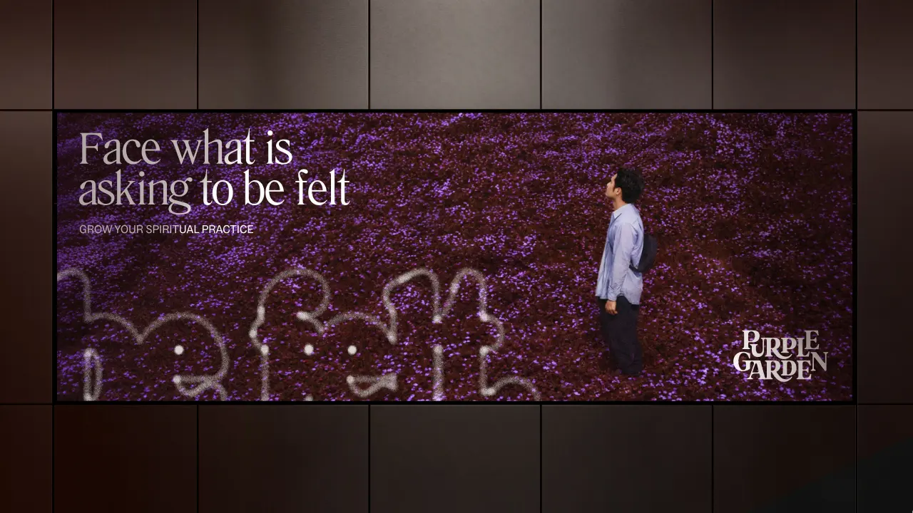 Person standing in purple flowering field with text reading "Face what is asking to be felt" and Purple Garden logo on dark billboard display