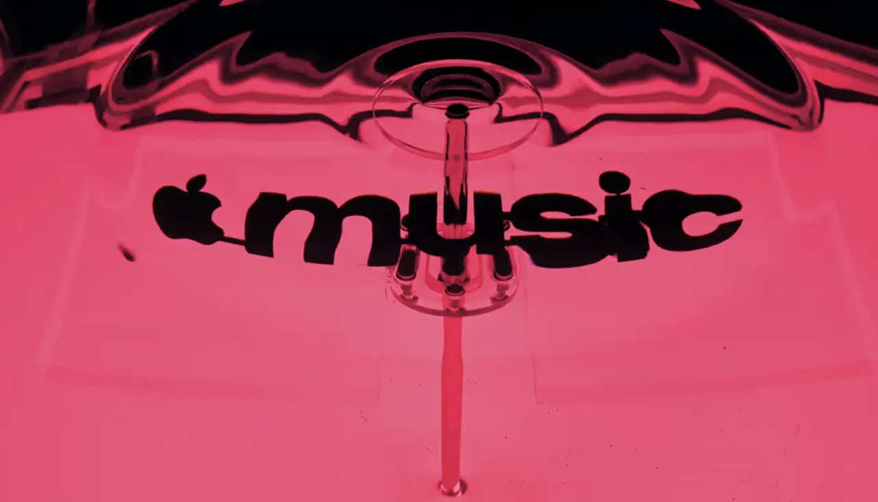 Apple Music logo in bright pink with a fluid, wave-like musical note design created from ripples in mineral oil