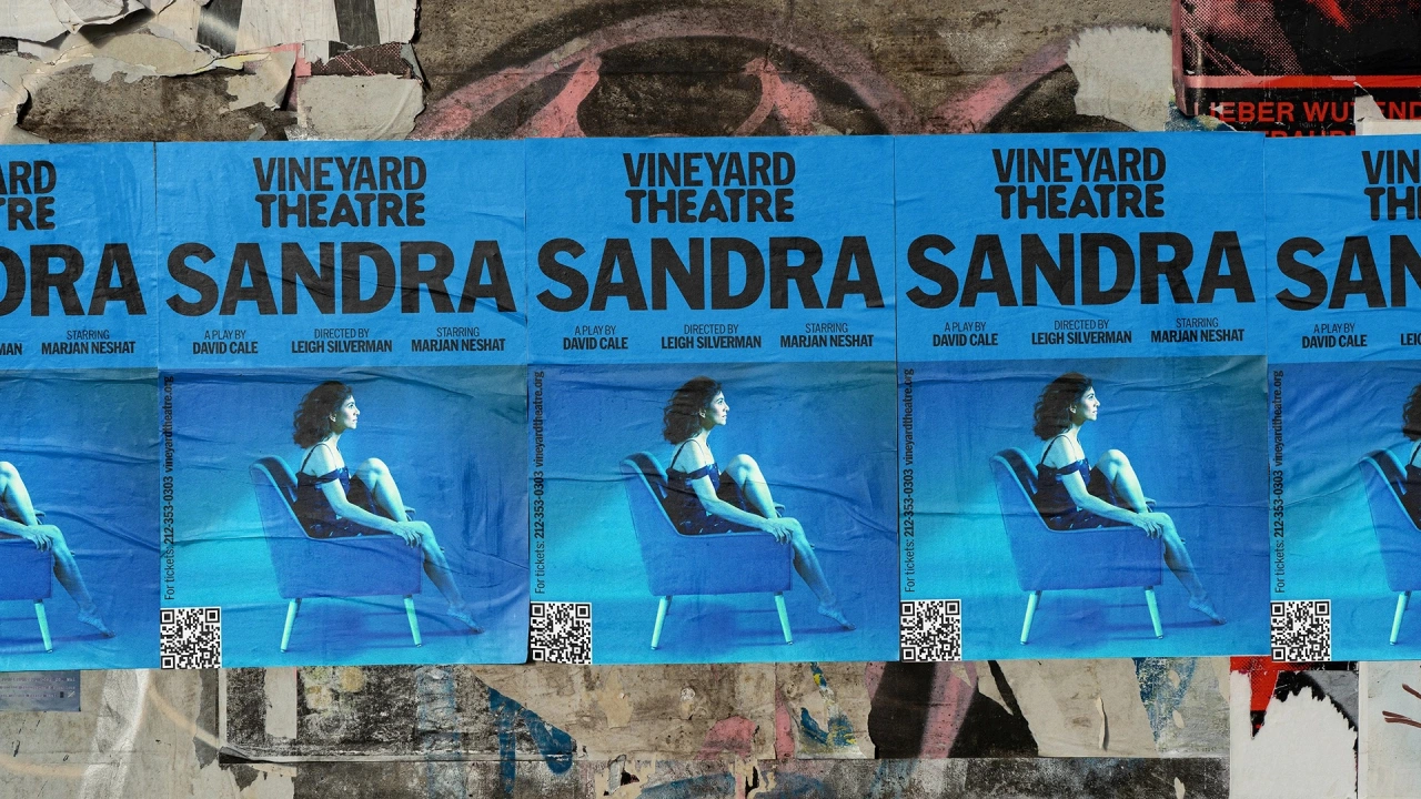 Blue promotional posters for Vineyard Theatre featuring a woman in a chair, repeated across a weathered wall surface