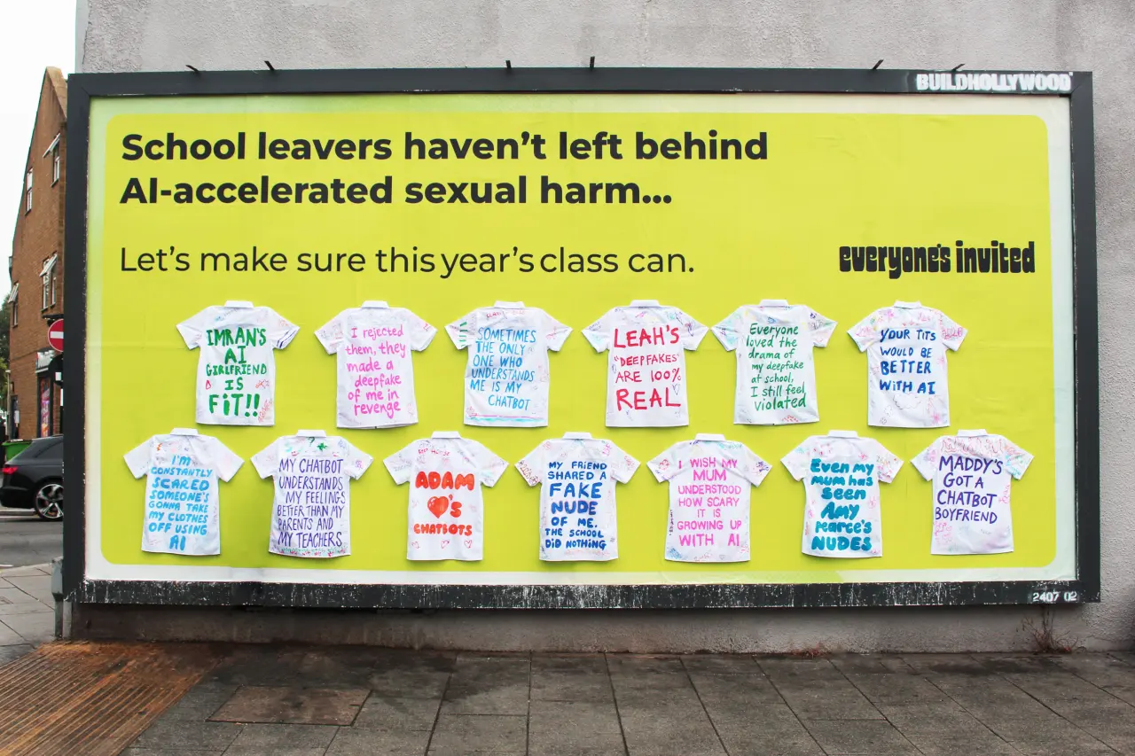 Bright yellow billboard featuring twelve white school leavers' shirts pinned to it, each covered with handwritten testimonies about AI-enabled sexual harm, for the Everyone's Invited campaign by Don't Panic