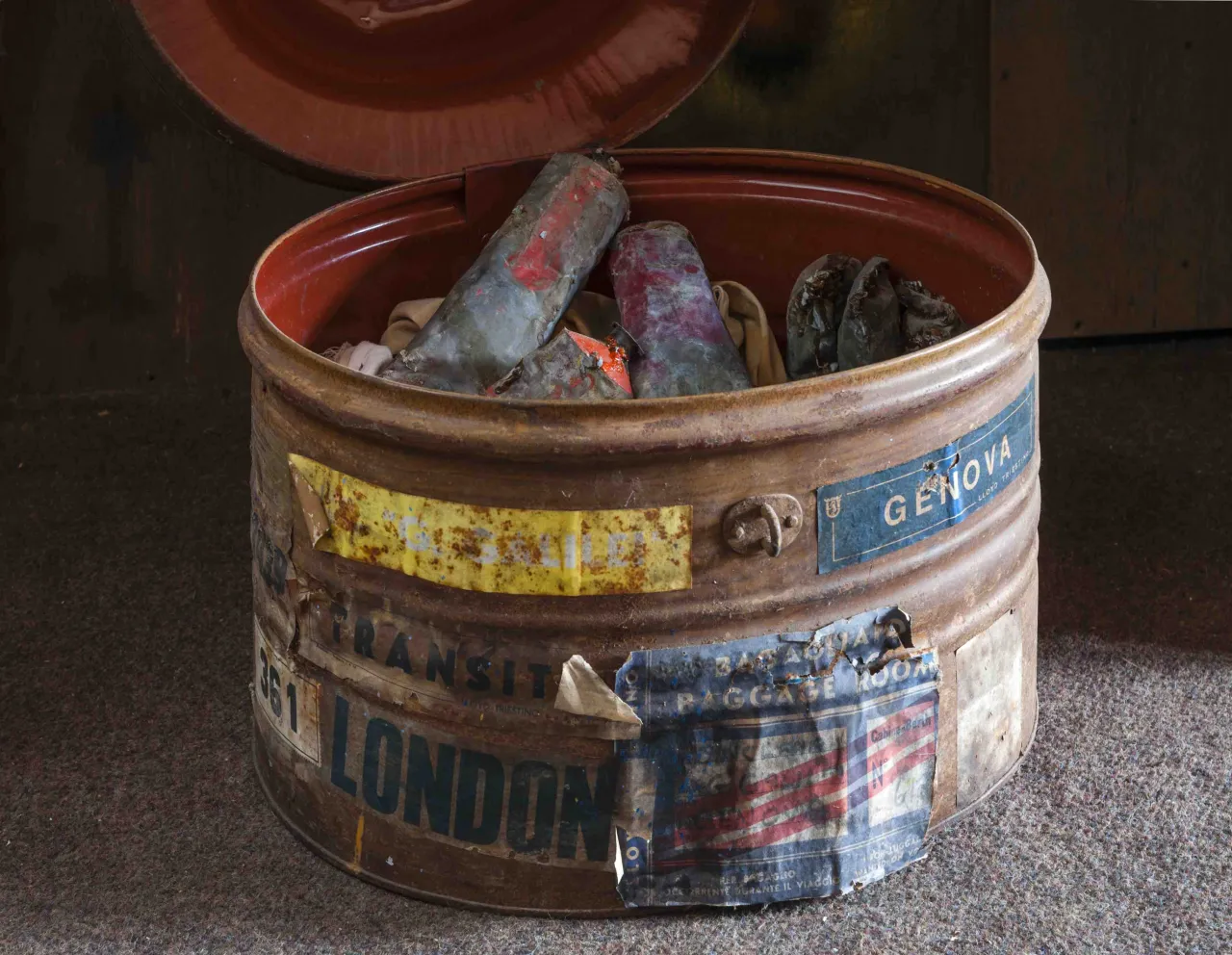 Weathered metal container with peeling labels filled with paint-covered brushes and art materials from Sidney Nolan's studio