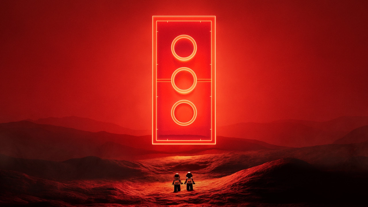 A neon red traffic light glows against a dark desert landscape with two silhouetted figures standing below it