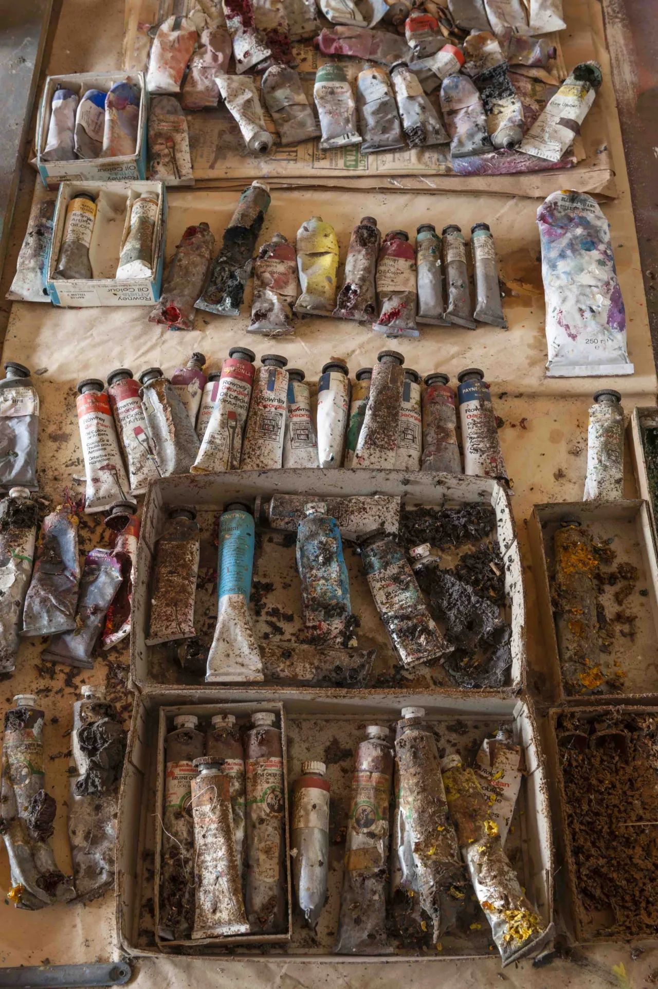 Organised wooden boxes and trays containing vintage paint tubes, spray cans and art materials accumulated in Sidney Nolan's studio over five decades