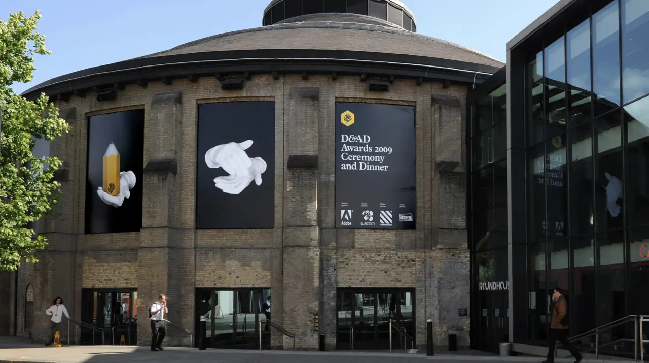 Circular stone building with large black windows displaying D&AD Awards 2009 branding and white graphic designs on its facade