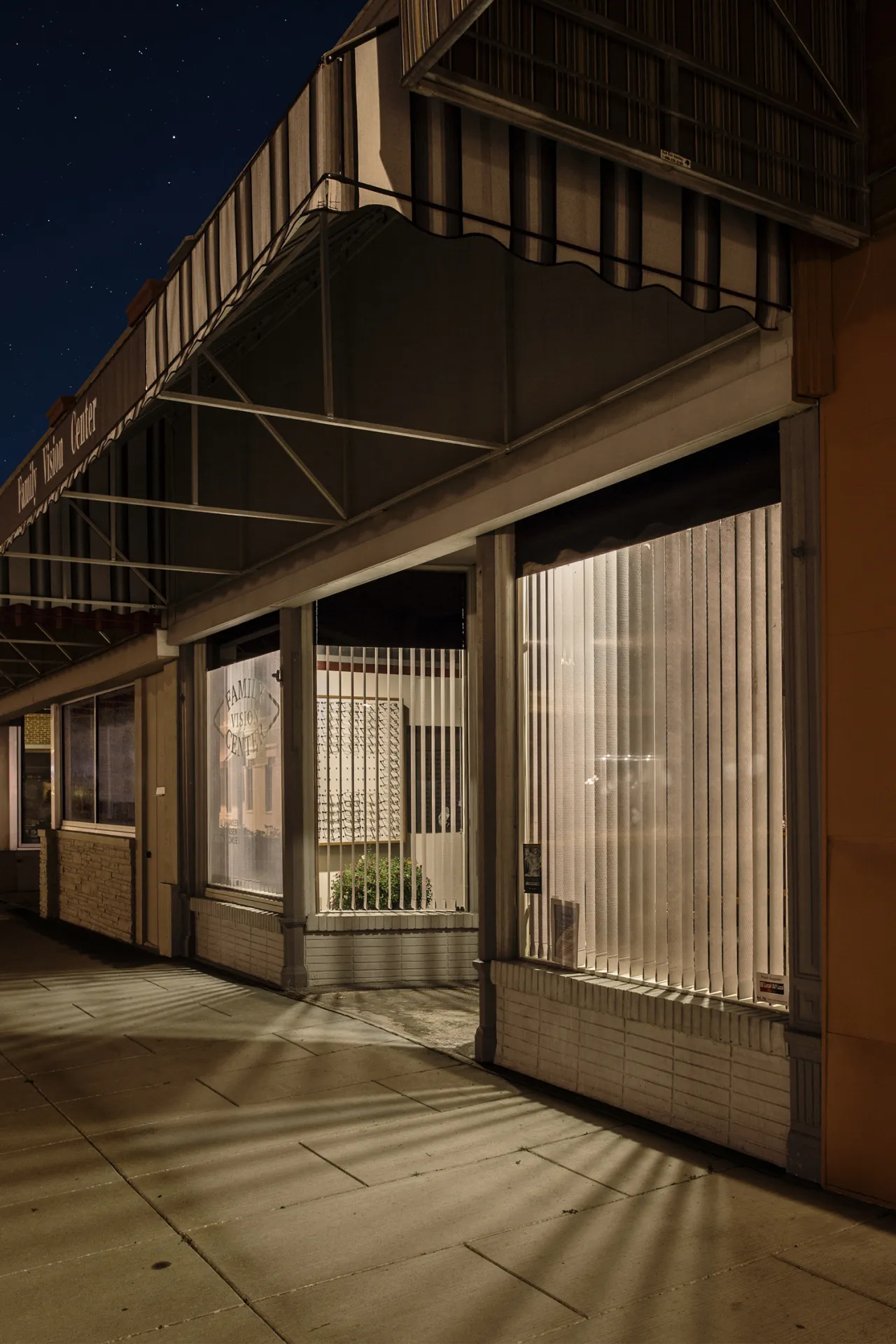 The lights of shop windows call out to the passer by at night in a silent and almost introvert desperation, attempting to entice potential customers for the following day’s opening hours.