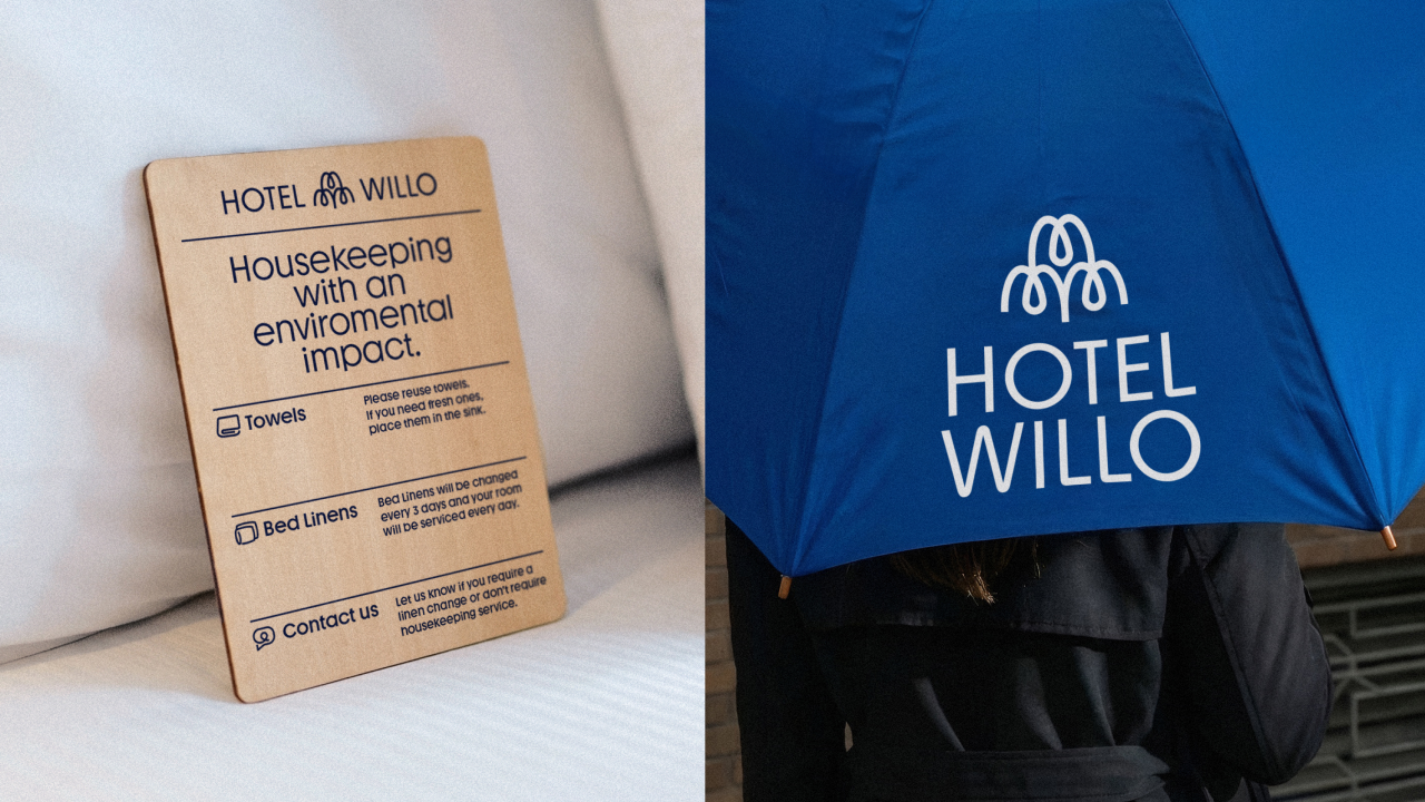 Hotel Willo wooden signage beside white pillows and blue umbrella featuring the hotel's logo and branding